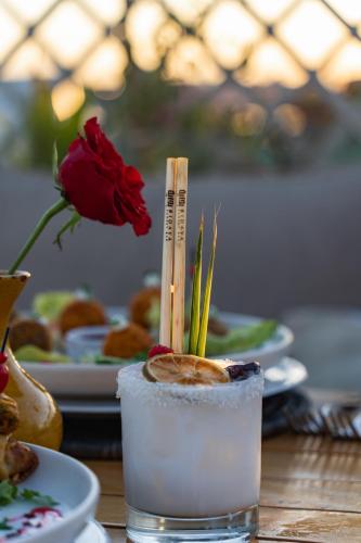 a drink on a table with a flower and plates of food at Almaha Marrakech Restaurant & SPA in Marrakech