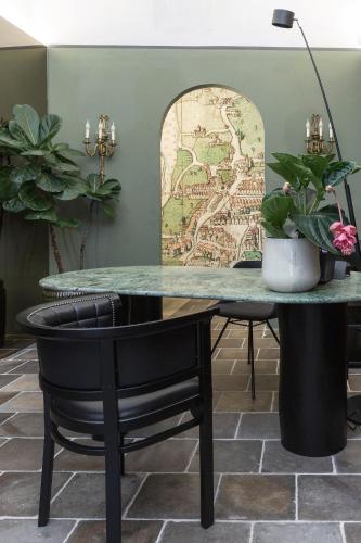 a table with a black chair in front of a map at Goldenstern Townhouse in Bolzano