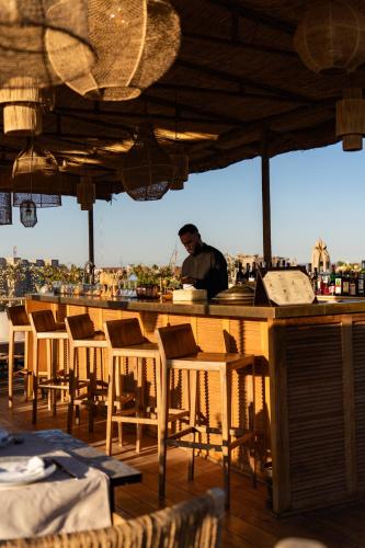 a man standing at a bar in a restaurant at Almaha Marrakech Restaurant & SPA in Marrakech
