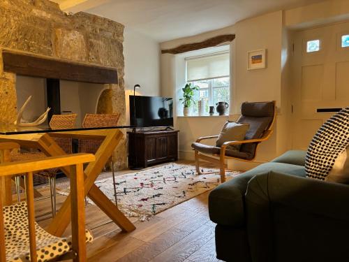 a living room with a couch and a fireplace at St Antony's Cottage in Stow on the Wold