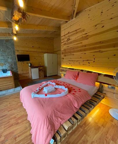 a bedroom with a large bed in a wooden room at VALLEY SUiT OTEL in Rize
