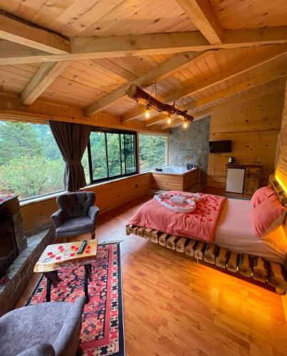 a bedroom with a large bed in a room with wooden ceilings at VALLEY SUiT OTEL in Rize