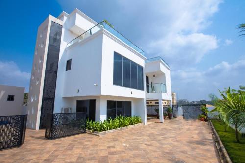 a large white house with a courtyard at Falcons Perch in Kumasi