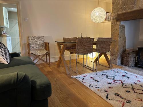 a living room with a dining room table and chairs at St Antony's Cottage in Stow on the Wold