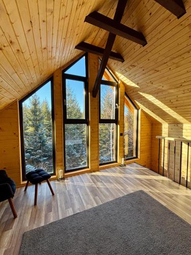 a large room with large windows in a wooden house at Apusenity- Refugiu modern în inima naturii, aproape de Cluj in Cluj-Napoca