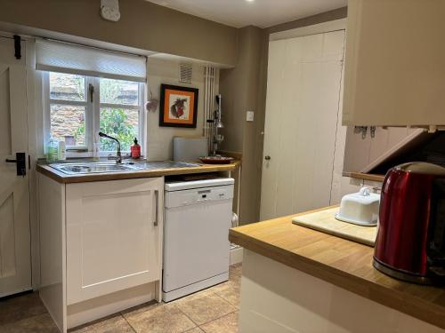 eine Küche mit Spüle und Geschirrspüler in der Unterkunft St Antony's Cottage in Stow on the Wold