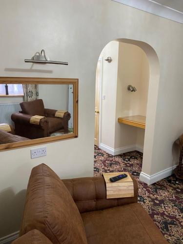 ein Wohnzimmer mit einer Couch und einem Spiegel in der Unterkunft Barons Court in Great Yarmouth