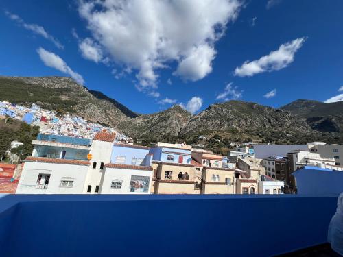 a view of a city with mountains in the background at Puerta Azul in Chefchaouene