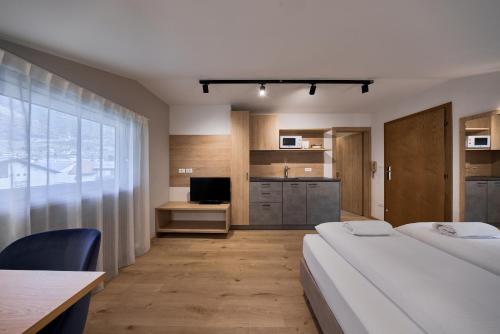 pokój hotelowy z 2 łóżkami i kuchnią w obiekcie Apartment Steinach w mieście Lagundo