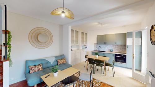 - un salon et une cuisine avec un canapé bleu et une table dans l'établissement Maison Beau Site, au Havre