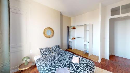 une petite chambre avec un lit et un miroir dans l'établissement Maison Beau Site, au Havre