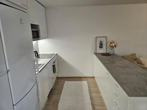 a kitchen with white appliances and a white refrigerator at Stylish top floor ap, with private parking, next to a tram stop in Tampere