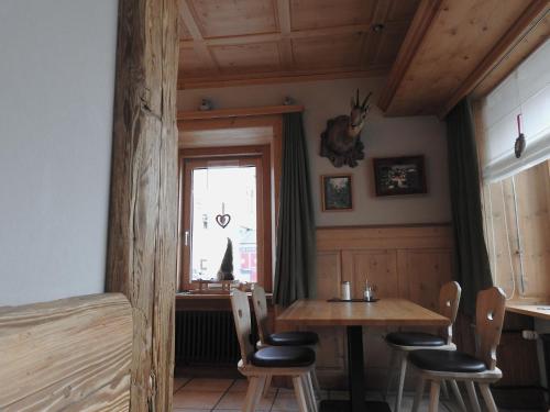 a dining room with a table and chairs and a window at Hotel Spöl Restaurant in Zernez