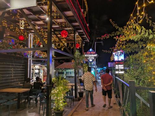 a group of people walking down a street at night at The Zen Zone in Varkala