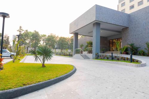 a building with a palm tree in front of it at Palms by Eagles Airport City, Formerly Holiday Inn in Accra