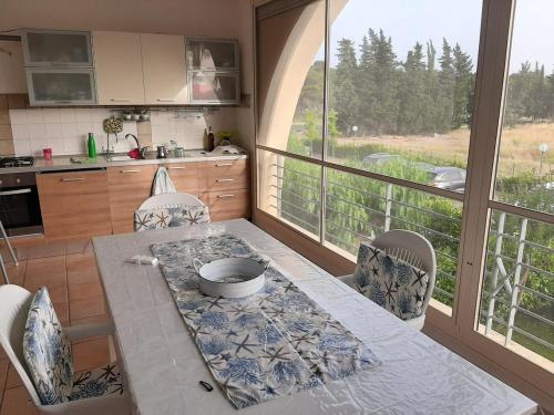 a kitchen with a table and chairs and a large window at SanBull Casa del Sole in Metaponto