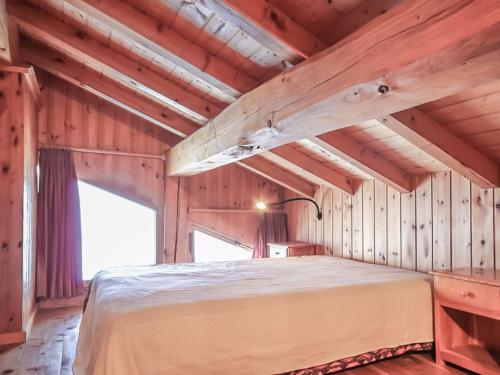 ein Schlafzimmer mit einem Bett in einem Holzzimmer in der Unterkunft Appartement Chalet Spacieux 6 Pièces, Wi-Fi, Vue Panoramique - FR-1-275-148 in Montvalezan