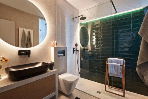 a bathroom with a sink and a toilet and a shower at Alti Parnassos Residences in Amfiklia