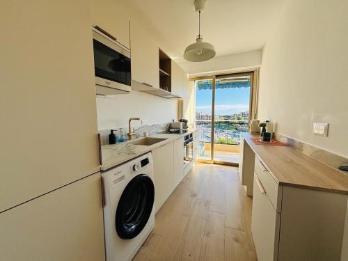 une cuisine avec une machine à laver et un évier dans l'établissement Le Pamplemousse - Stunning 1 Bedroom Quiet Pool, à Mandelieu-la-Napoule
