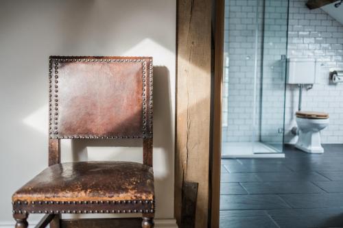 a rusty chair in a bathroom with a toilet at The Redan Inn in Chilcompton