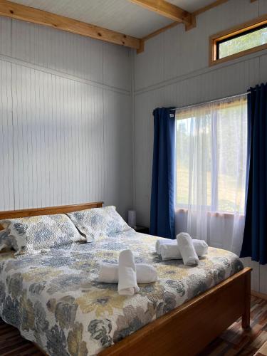 a bedroom with a bed with two towels on it at Cabaña playa Chauquen, Panguipulli in Panguipulli