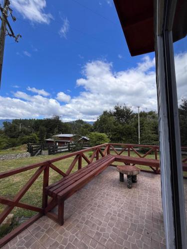 a wooden bench sitting on top of a wooden fence at Cabaña playa Chauquen, Panguipulli in Panguipulli