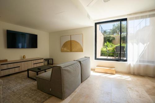 a living room with a couch and a tv and a window at Messinian Nest in Gialova