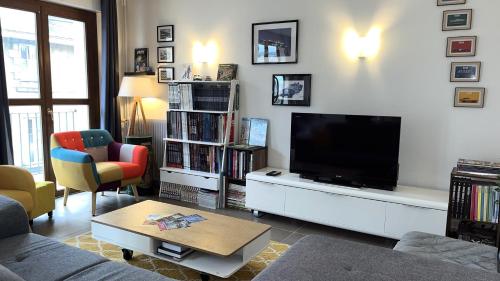 un salon avec une télévision à écran plat et un canapé dans l'établissement Les Rallyes de la Loire - Vue sur Loire - 4 pers, à Blois