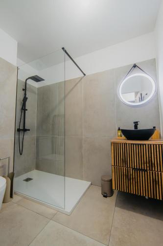 une salle de bain avec une douche en verre et un lavabo dans l'établissement Love Room - Balnéo - Nuit Insolite - Intimité, à Toulouse