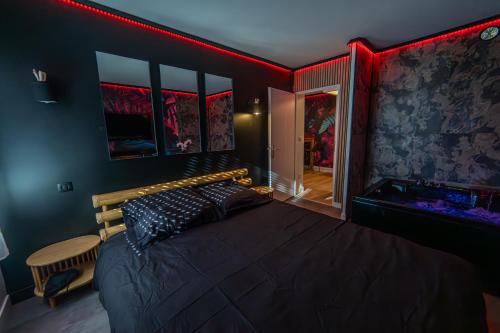 a bedroom with a bed in a room with red lighting at Love Room - Balnéo - Nuit Insolite - Intimité in Toulouse