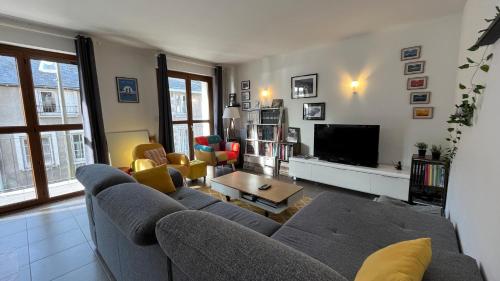 un salon avec un canapé et une télévision dans l'établissement Les Rallyes de la Loire - Vue sur Loire - 4 pers, à Blois