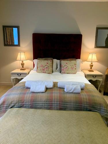 a bedroom with a large bed with two night stands at The Old Hunting Lodge at The Talbot Inn in Tenbury