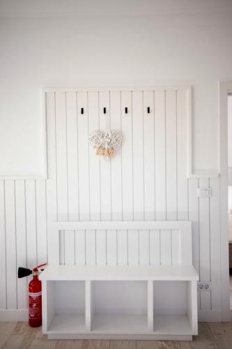 a white bench in a room with a white wall at FLH - Algo Bueno in Suceava