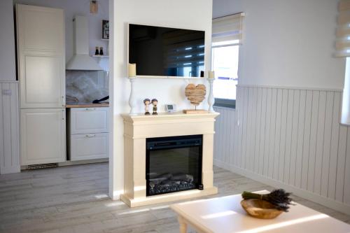 a living room with a fireplace with a tv above it at FLH - Algo Bueno in Suceava