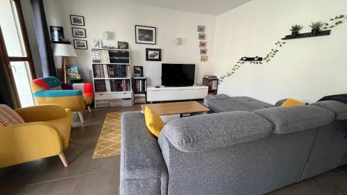 un salon avec un canapé et une télévision dans l'établissement Les Rallyes de la Loire - Vue sur Loire - 4 pers, à Blois