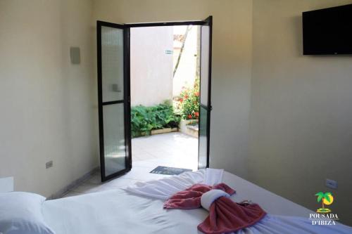 a bedroom with a bed with a sliding glass door at Pousada D'Ibiza - Itanhaém in Itanhaém