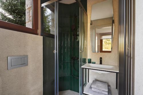 a bathroom with a shower with a sink and a mirror at Alti Parnassos Residences in Amfiklia