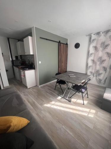 un salon avec une table et une cuisine dans l'établissement logodrine2, à Lalouvesc