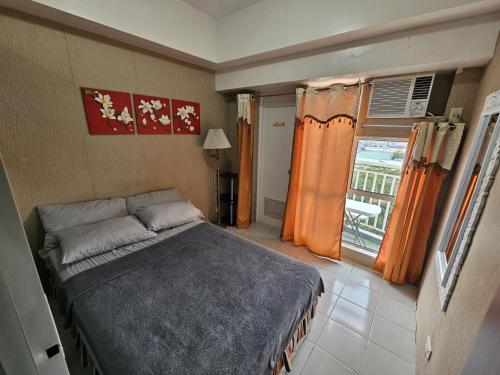 a small bedroom with a bed and a window at Fullhouse Staycation in Tagaytay