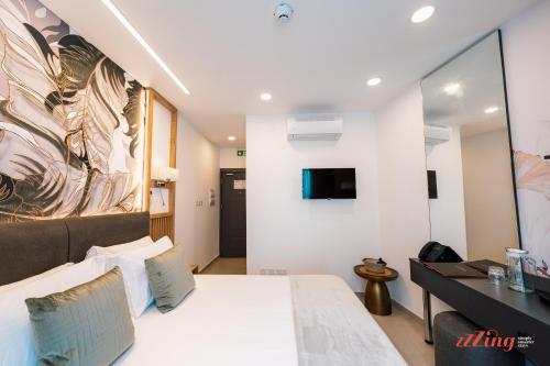 a hotel room with a bed and a tv at El Doris Boutique Living St Julian's in St. Julianʼs