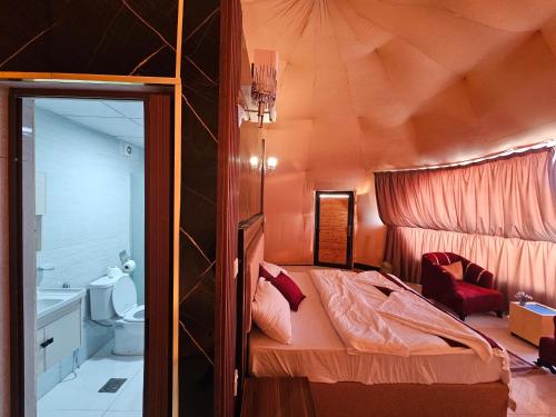 a small bedroom with a bed and a bathroom at Russell desert luxury camp in Wadi Rum