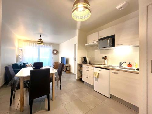 une cuisine et une salle à manger avec une table et une cuisine ainsi qu'une chambre dans l'établissement REMENBER - T2 proche océan, à Mimizan-Plage