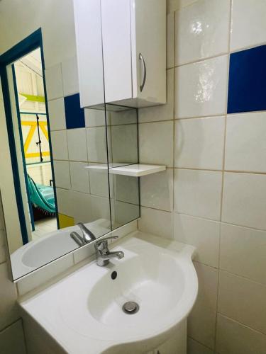 a bathroom with a white sink and a mirror at Bungalow Atoll Sainte-Anne in Sainte-Anne