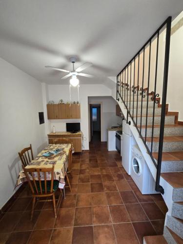 a dining room with a table and a staircase at Casa rosa in Palau