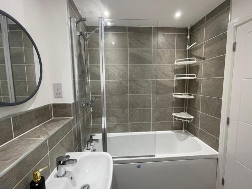 a bathroom with a sink and a bath tub at Cozy double room in Wavendon