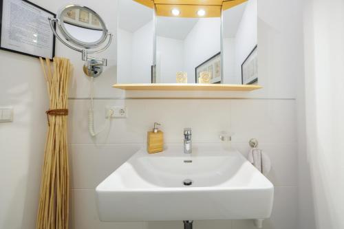 a bathroom with a white sink and a mirror at Luxury Apartment Villach City in Villach