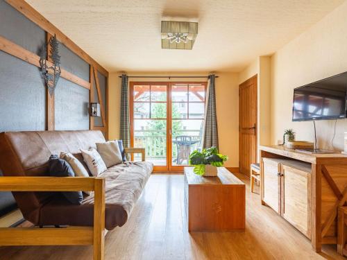 un salon avec un canapé et une télévision dans l'établissement Appartement 1 chambre, piscine, sauna, parking en hyper centre-ville - FR-1-296-432, à Saint-Lary-Soulan