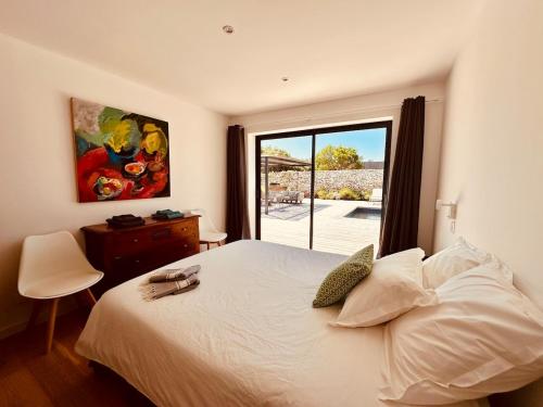 une chambre avec un lit blanc et une grande fenêtre dans l'établissement Villa Gioia- Charme et sérénité, à Bonifacio