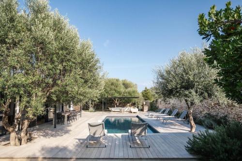 une cour avec une piscine, des chaises et des arbres dans l'établissement Villa Gioia- Charme et sérénité, à Bonifacio
