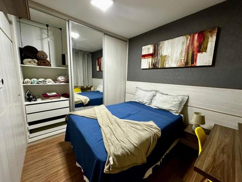 a bedroom with a blue bed and a mirror at Apartamento planejado in Gama